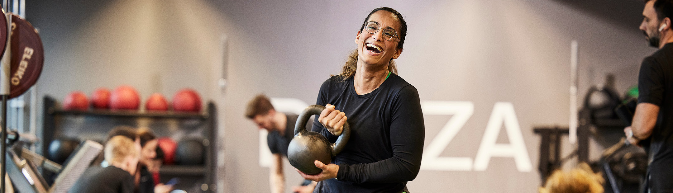 Kvinna som tränar med kettlebell i Friskis gym